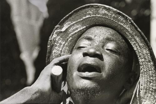 Man holding hand up to ear while singing, Tamale, Ghana