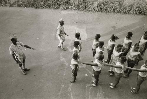Officer instructing lines of women, Guinea