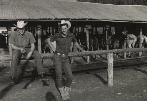 Two cowboys in front of stabled horses, Sterling, Colorado