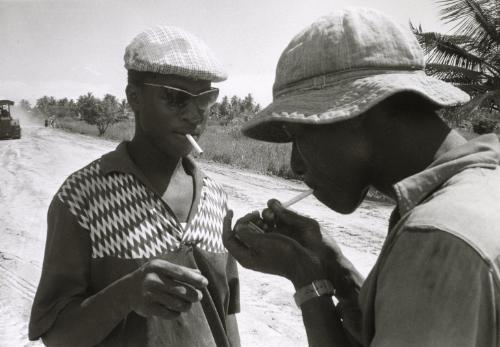 Two men lighting cigarettes, Ghana