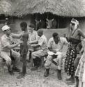 UNICEF doctors examine patients in front of a barn housing oxen, Nigeria, Africa