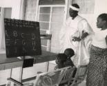 Family at home teaching their children the alphabet, likely Dakar, Senegal, Africa