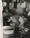Mother bathing her infant, Latin America