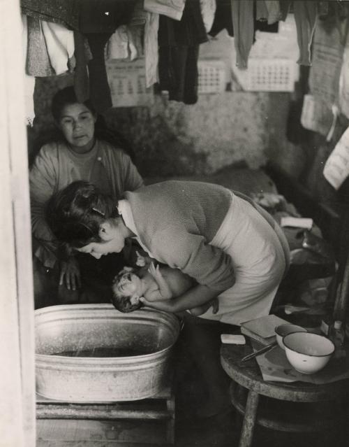Mother bathing her infant, Latin America