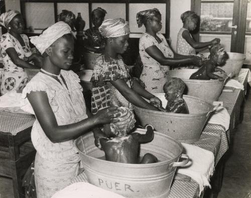 Mothers bathing their babies at a baby care course at the Red Cross, Leopoldville, the Belgian Congo (now Kinshasa, Democratic Republic of the Congo)