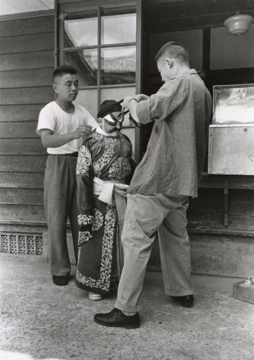 American boy at marital arts school being dressed in traditional costume, Taiwan