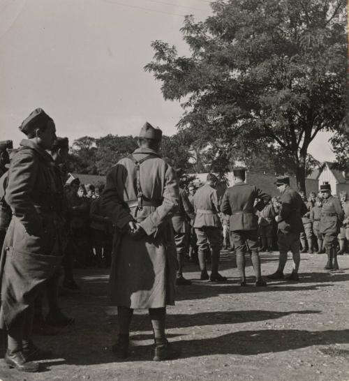 Paris Racing Stables Are Army Quarters: Paris' famous racing stables or Maison-Laritte have be requisitioned by the military authorities and are now quarters for the Army. The premises which used to house famous thoroughbreds of the racetracks are now occupied soldiers who try to make themselves at home as much possible. / Soldiers assembling for the roll call in front of the stables.