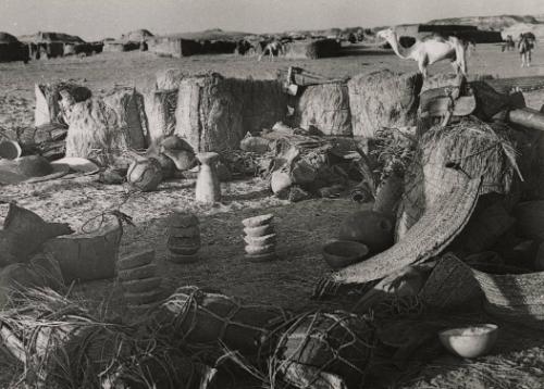 Untitled (Water gourds, stone bowls and barrels of hay with camels), Africa